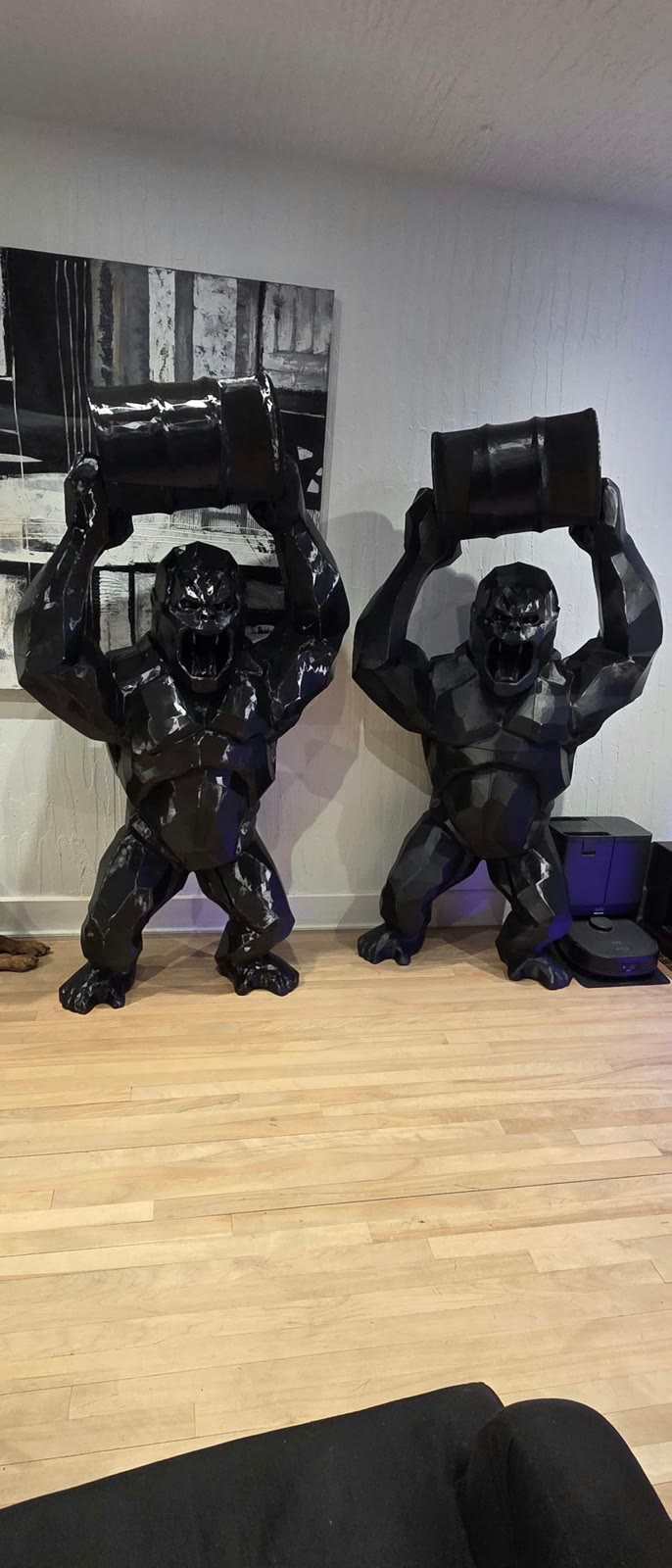 Deux grands gorilles à facettes qui soulèvent un baril, imprimés en 3D